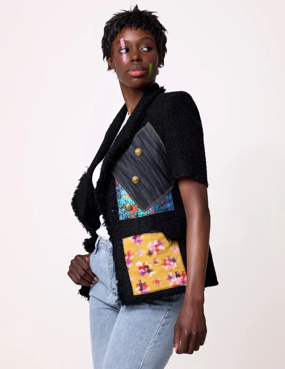 JUS10H Black Summer Jacket editorial, side profile detail of black tweed jacket with gray denim, multicolor, and yellow ikat patchwork panels and gold buttons, white background, photographed by Scott Parker Photo