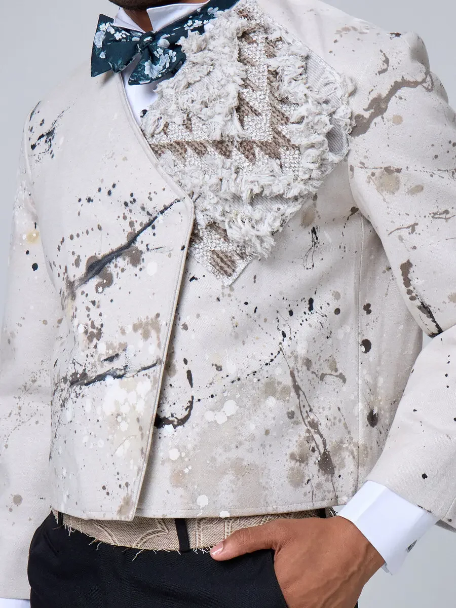 JUS10H 2025 New York Bridal Fashion Week, close detail of ivory abstract paint-splatter tuxedo jacket with dimensional lace lapel and dark teal floral bow tie, photographed by Scott Parker Photo