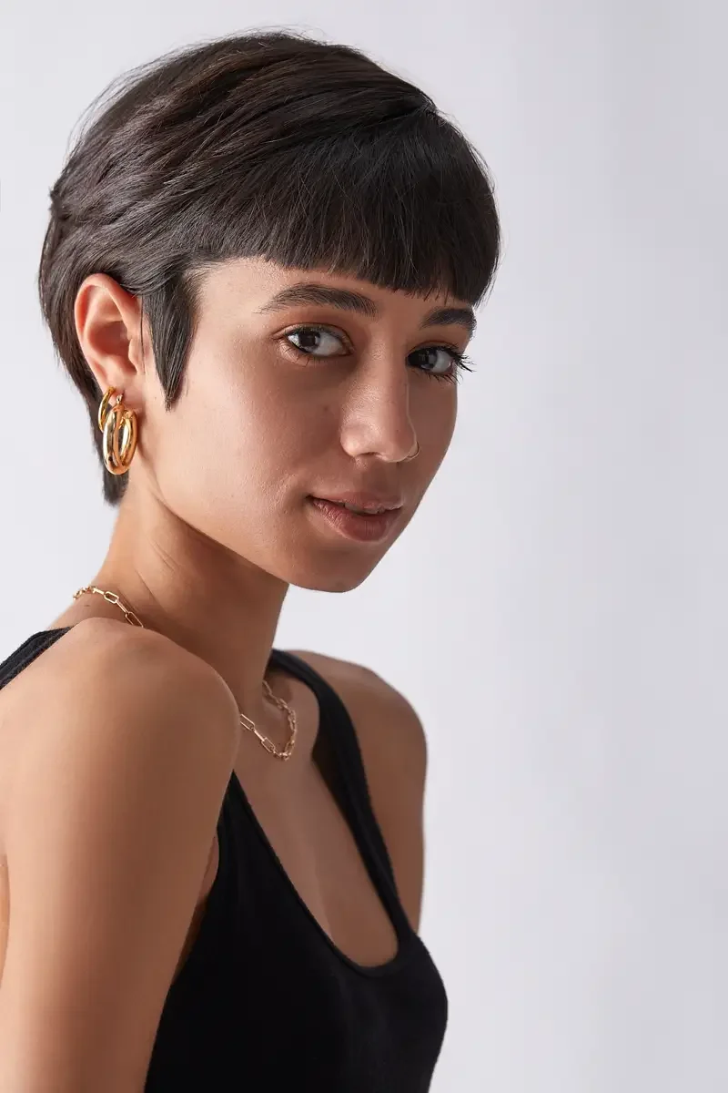 Eloissa, three-quarter portrait, gold hoop earrings and chain necklace, black tank, pixie cut, East Williamsburg studio test shoot, makeup by Schanica Pickens, photographed by Scott Parker Photo