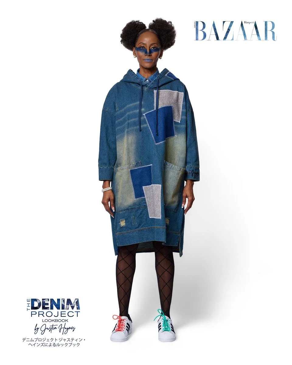 JUS10H Denim Project 2025 Harper's Bazaar Japan lookbook — model in oversized medium-wash hooded denim coat dress with bold geometric navy and grey patchwork panels and acid-wash detailing, denim shirt underlayer, fishnet tights, blue editorial makeu