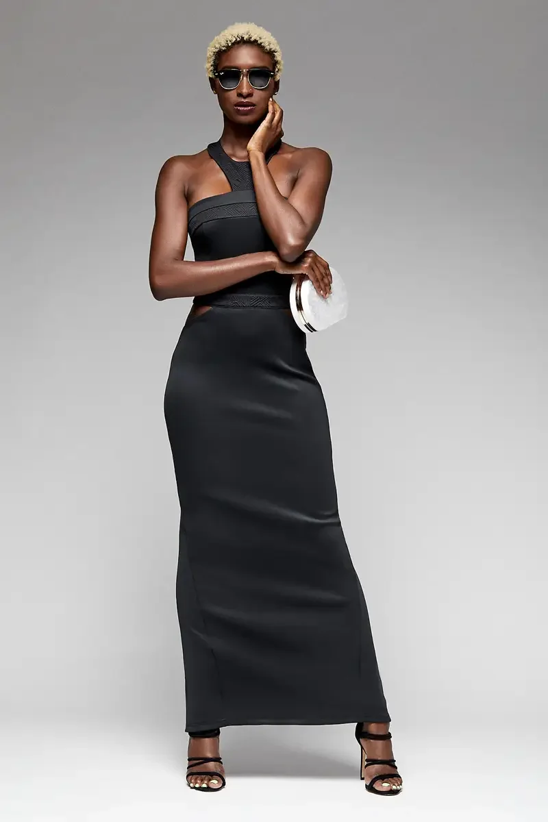 Minika Ko lookbook, black halter gown, three-quarter view, jacquard halter strap, cutouts at waist, floor-length smooth synthetic skirt, white circular clutch, dark sunglasses, photographed by Scott Parker Photo