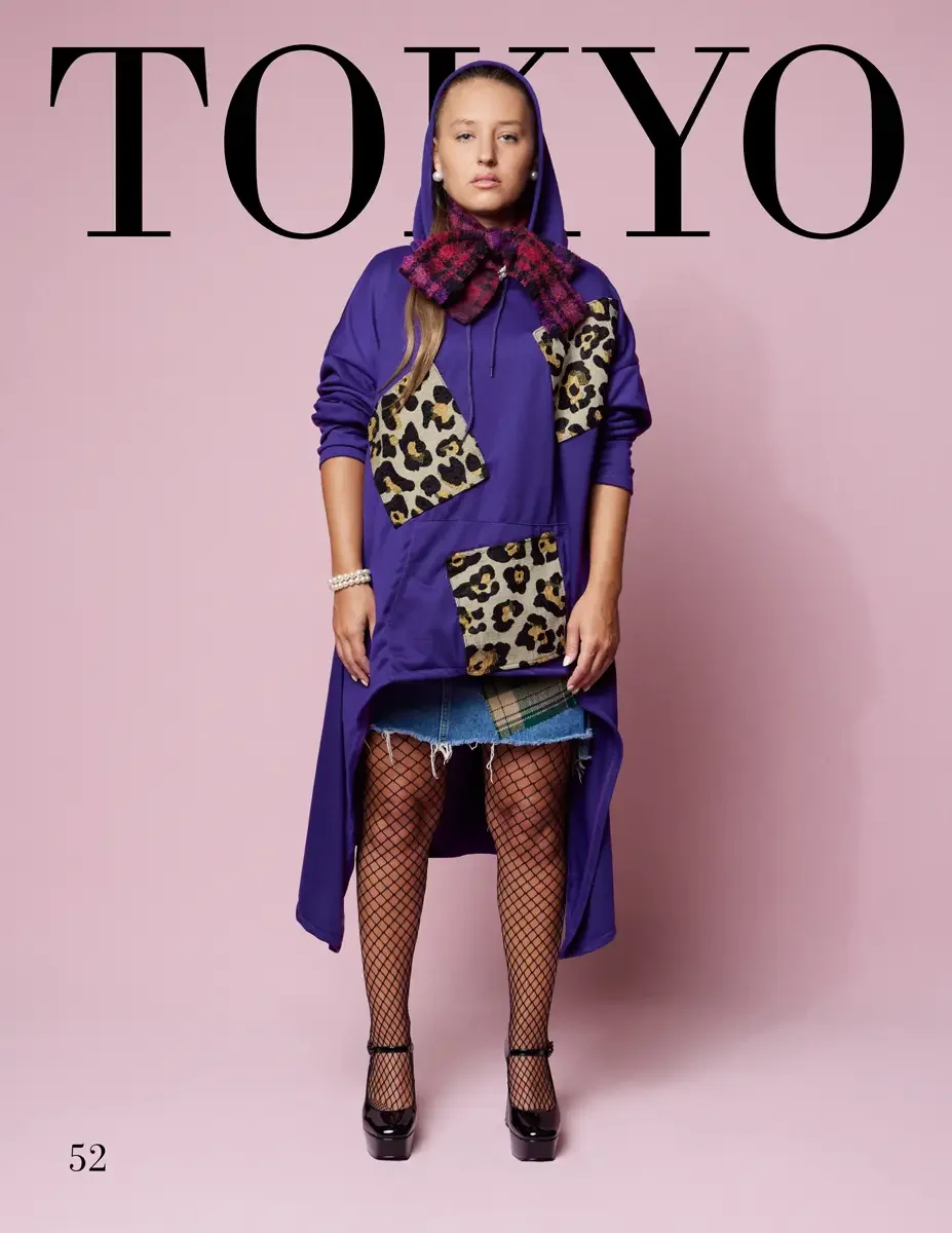 JUS10H 2025 Tokyo lookbook, a female model wearing an oversized purple hoodie dress with leopard print patchwork appliqués on the chest and kangaroo pocket, a purple hood up, a burgundy and pink plaid fringe scarf at the neck, a raw-hem denim and pla