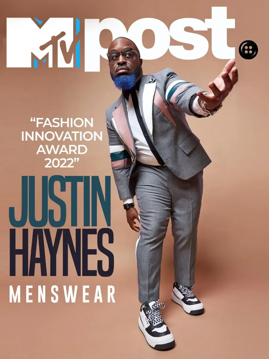 JUS10H 2022 MTV Post feature, Fashion Innovation Award, full-length editorial cover, grey suit with colour-block patchwork lapels, dynamic reaching pose, photographed by Scott Parker Photo