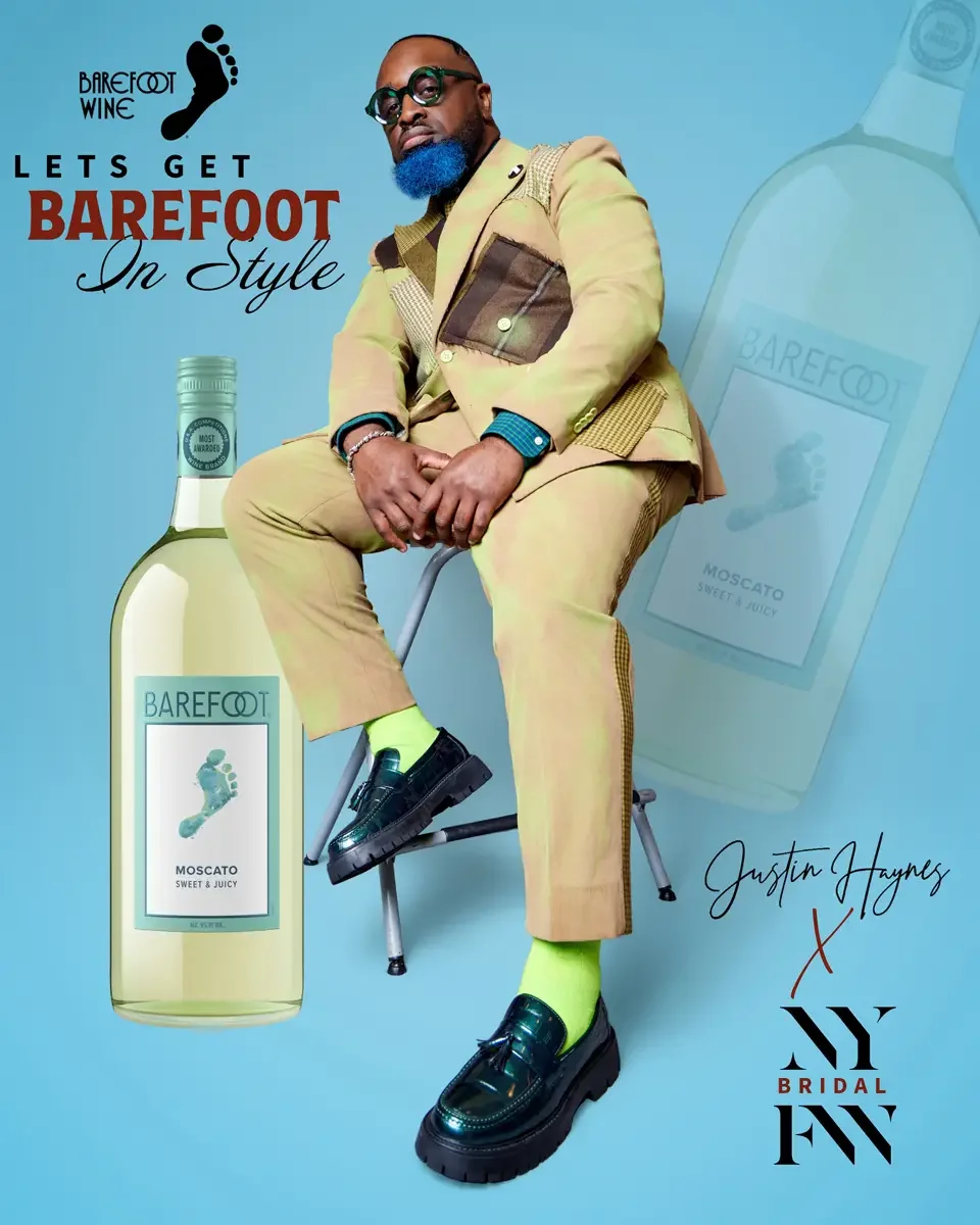 JUS10H 2025 Barefoot Wine cross-promotional campaign, New York Bridal Fashion Week, seated editorial portrait in tan patchwork suit with neon green socks, blue background, photographed by Scott Parker Photo