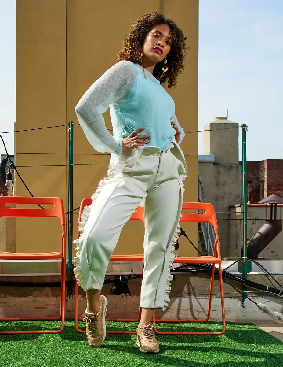 Fashion test shoot, model Ireland T in Amy Page DeBlasio white ruffle-trim pants with front zipper and aqua sheer knit top, East Village rooftop, New York City, styling by Matsine Stinson, makeup by Stefani Paige Vivian, photographed by Scott Parker 