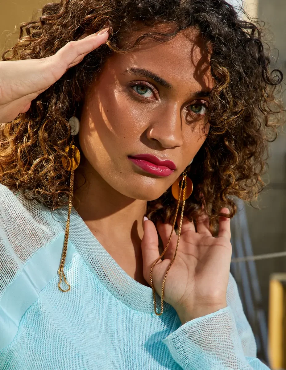Fashion test shoot, beauty portrait, model Ireland T in aqua sheer knit top, amber disc drop earrings, makeup by Stefani Paige Vivian, East Village rooftop, New York City, styling by Matsine Stinson, photographed by Scott Parker Photo