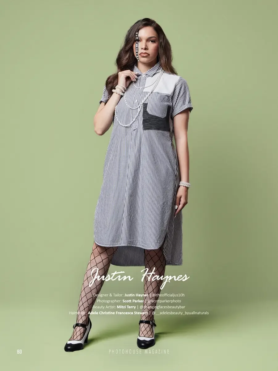 JUS10H 2025 Photohouse Magazine feature, model in navy and white pinstripe oversized shirtdress with white patchwork panel and ruched metallic pocket, layered pearl chain necklace, fishnet tights and black bow Mary Janes, sage green background, photo