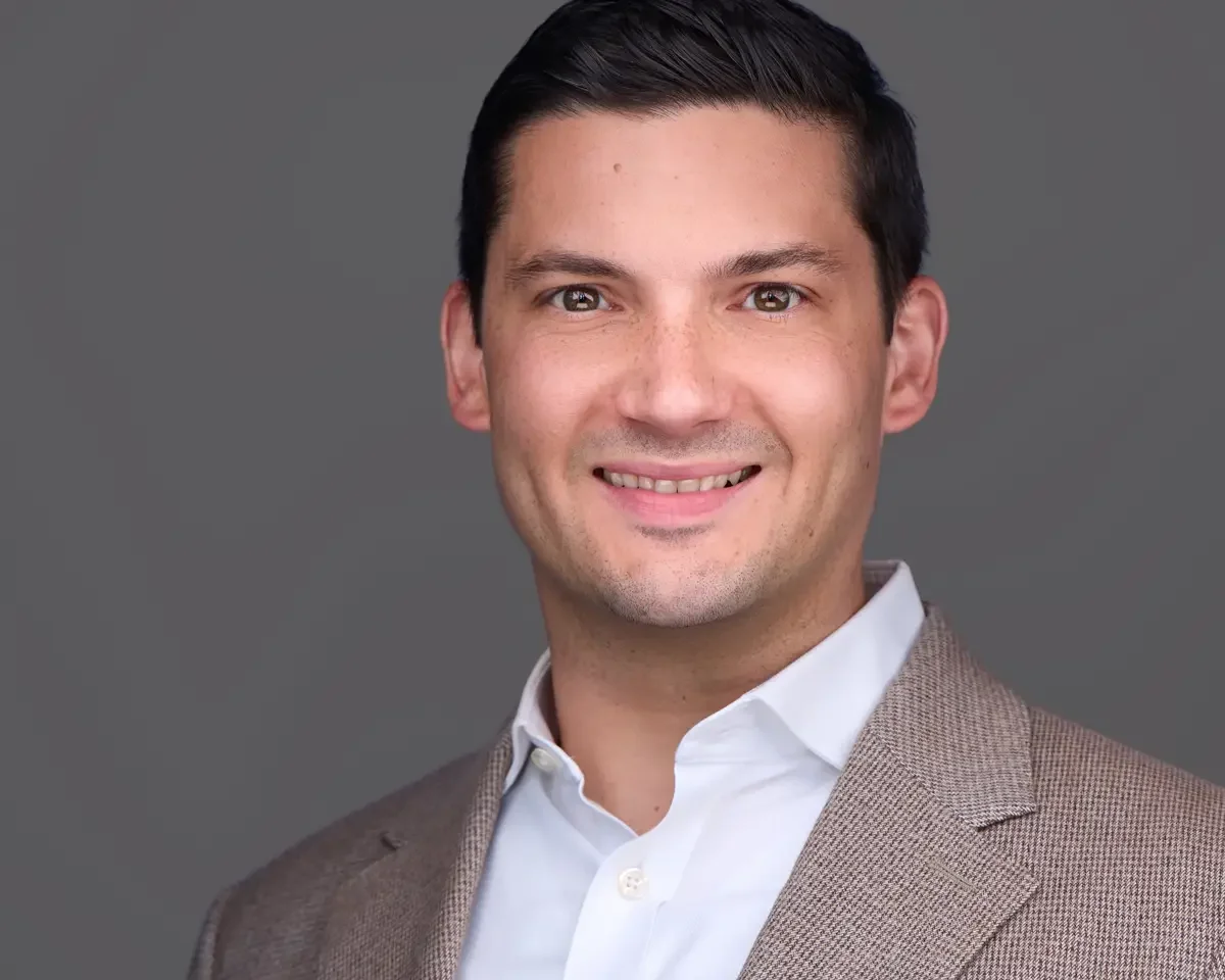 Financial advisor headshot, tan houndstooth blazer and light blue shirt, relaxed professional expression, gray background, Connecticut, photographed by Scott Parker Photo