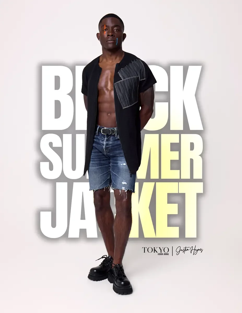 JUS10H Black Summer Jacket lookbook, male model in black collarless short-sleeve jacket with gray patchwork panel worn open, no shirt, distressed denim shorts, black lace-up boots, white background, photographed by Scott Parker Photo