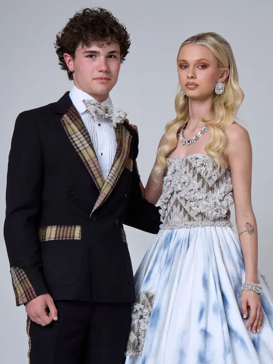 JUS10H 2025 New York Bridal Fashion Week, black shorts suit with plaid lapels, cuffs, and pocket trim alongside ice-blue tie-dye ball gown with strapless dimensional lace bodice and lace patch appliqué skirt, styled with crystal statement necklace an