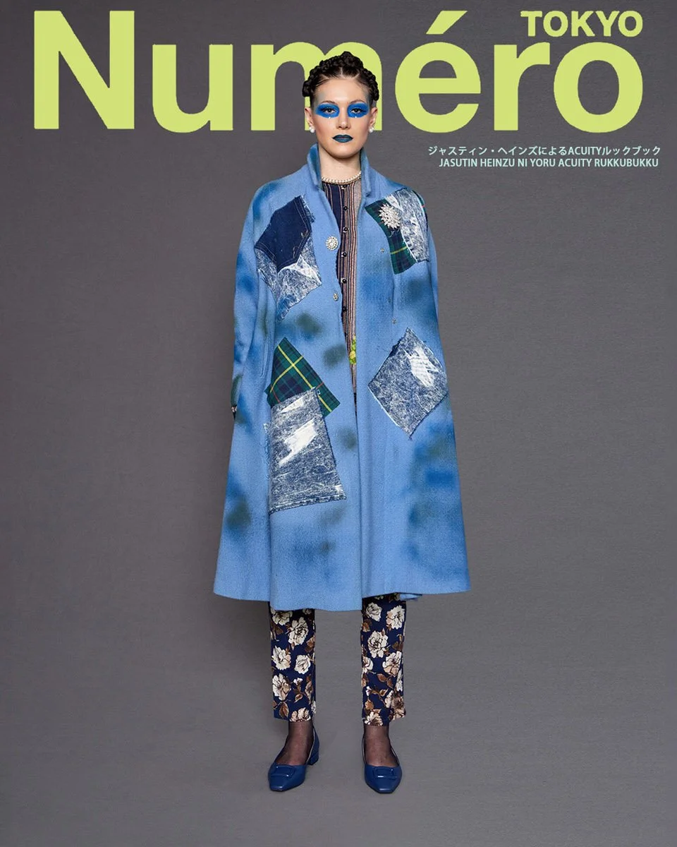 JUS10H by Justin Haynes ACUITY Collection lookbook for Numéro Tokyo by Scott Parker — model in light blue wool A-line coat with denim, acid-wash, and tartan patchwork panels, layered over striped and embellished button-up, paired with navy and cream 