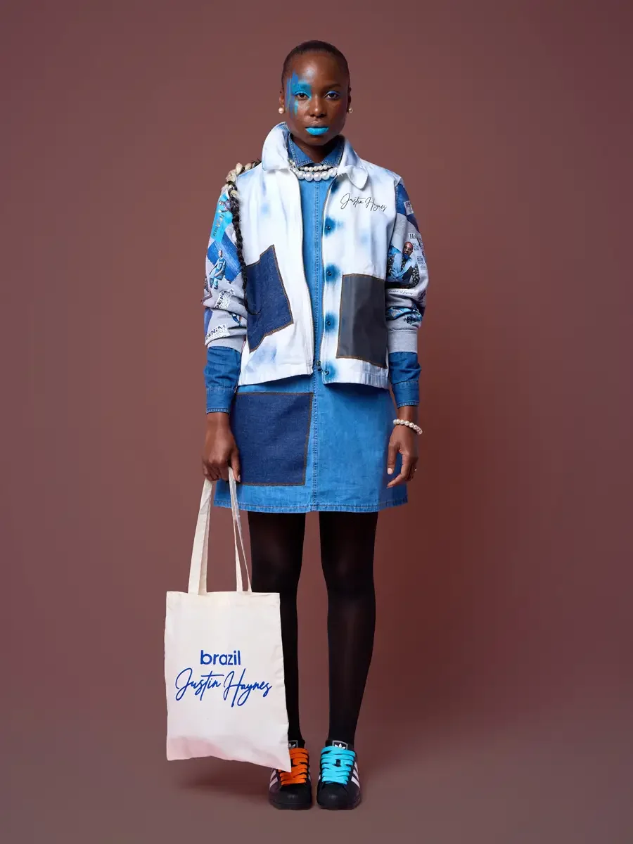 Printed sleeve of the lookbook sweatshirt over a denim skirt, tote at the side, JUS10H Court Show