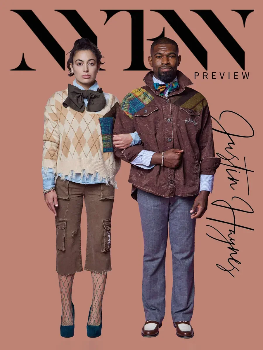 JUS10H 2025 promotional image, two models standing together with Justin Haynes script signature, female in camel argyle fringe sweater with olive bow and brown cargo capris, male in brown washed field jacket with multicolor tartan patchwork shoulder 