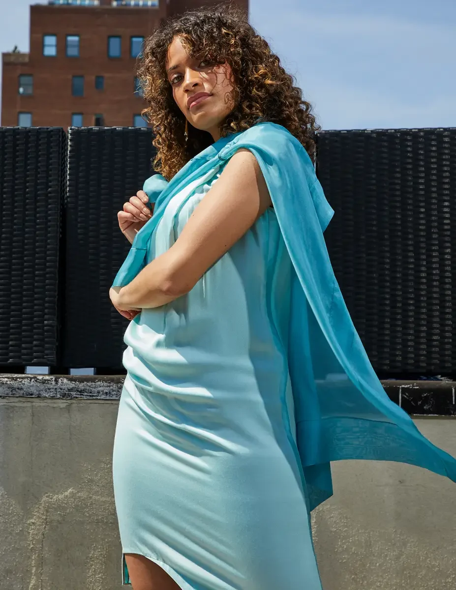 Fashion test shoot, three-quarter, model Ireland T in aqua sleeveless midi dress with turquoise sheer wrap draped over shoulder, East Village rooftop, New York City, styling by Matsine Stinson, makeup by Stefani Paige Vivian, photographed by Scott Pa