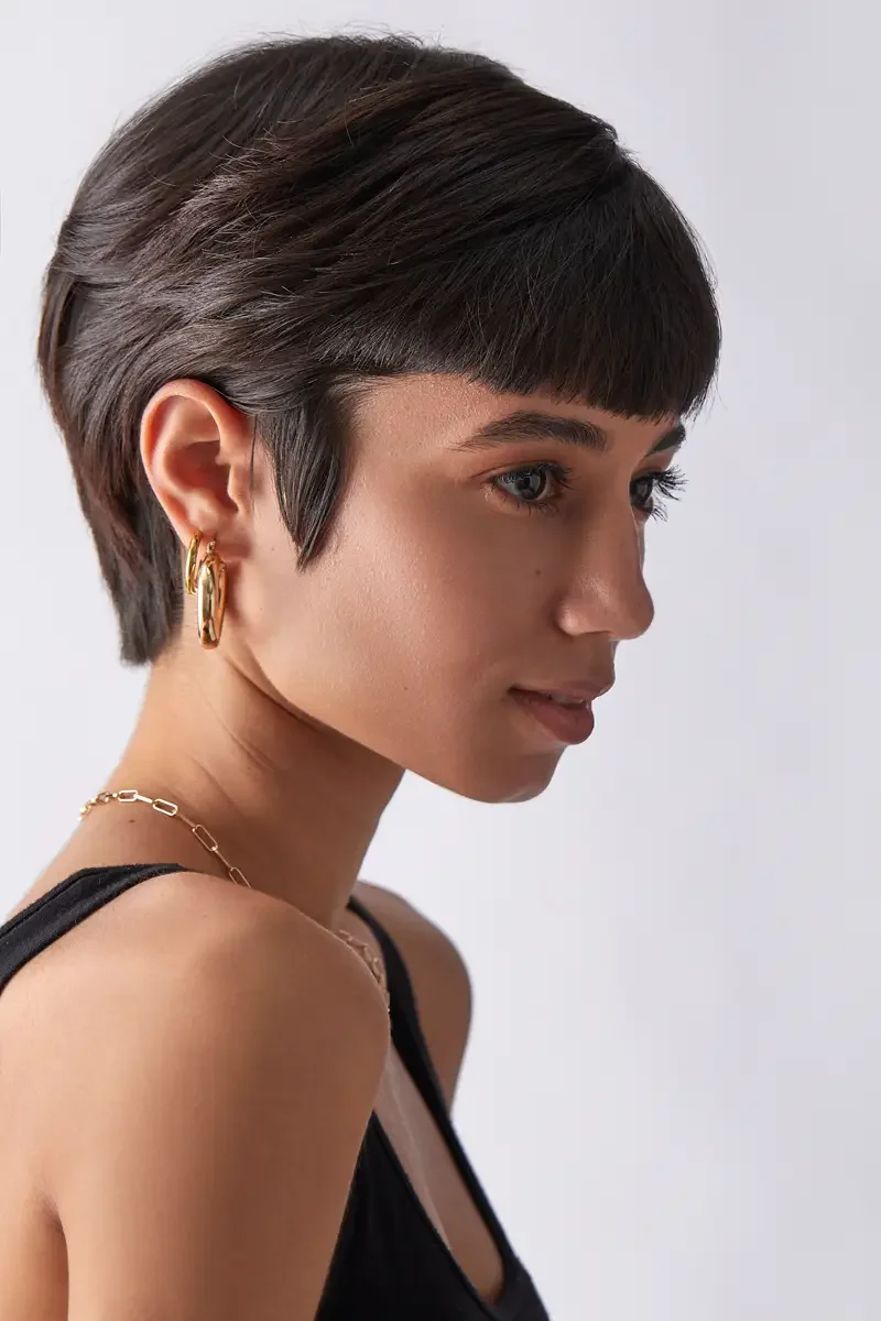 Eloissa, clean profile portrait, gold hoop earrings and chain necklace, pixie cut with blunt fringe, black tank, East Williamsburg studio test shoot, makeup by Schanica Pickens, photographed by Scott Parker Photo