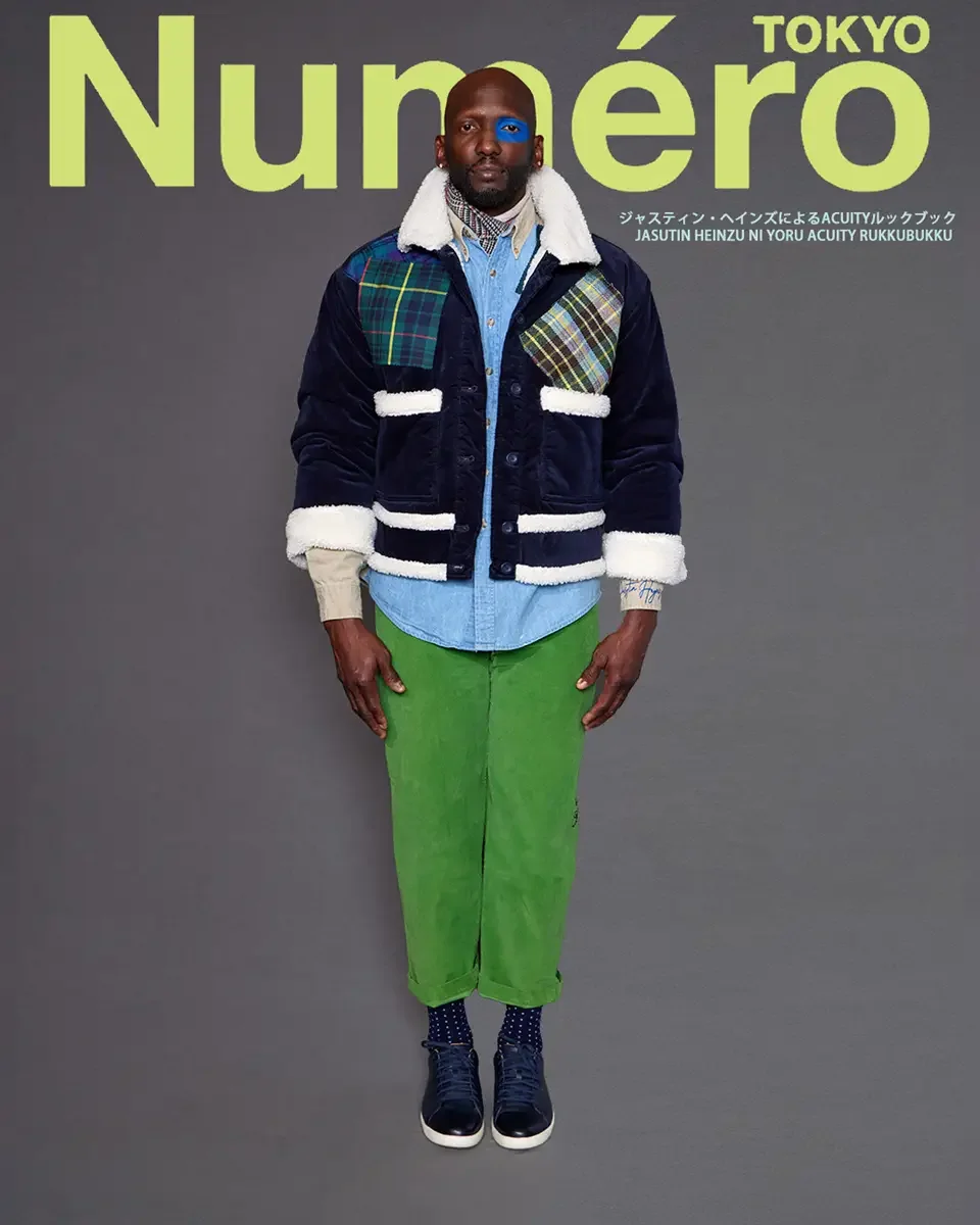 JUS10H 2025 Numéro Tokyo feature, full-length editorial, navy corduroy sherpa jacket with patchwork tartan detail, green wide-leg trousers, grey background, photographed by Scott Parker Photo