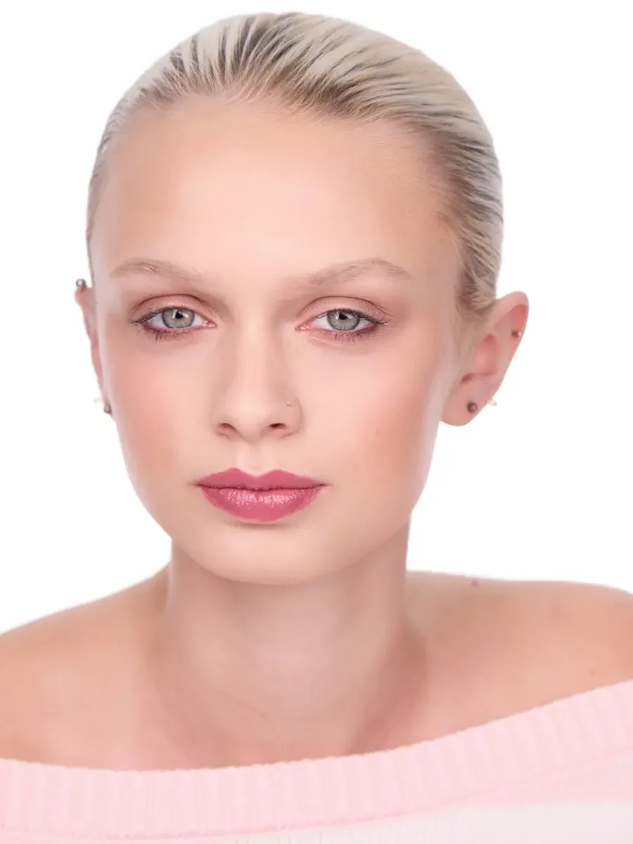 Model portfolio development session, beauty, close-crop, hair slicked back, face forward, direct gaze, rose lip, soft eye, pink off-shoulder sweater, white background, photographed by Scott Parker Photo, New York