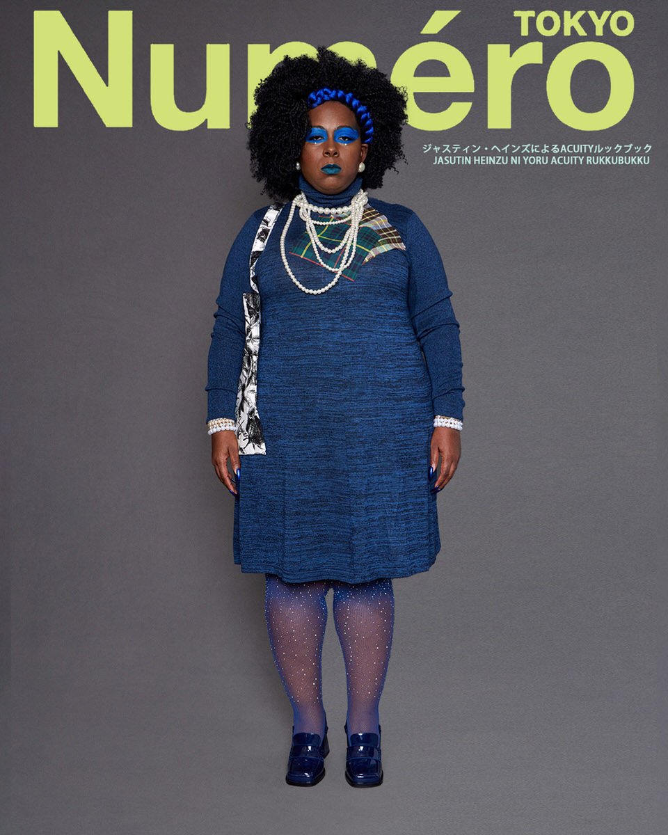 JUS10H by Justin Haynes ACUITY Collection lookbook for Numéro Tokyo by Scott Parker — model in navy marled knit turtleneck dress with tartan patch pocket and floral-print sash detail, layered pearl necklaces, blue rhinestone tights, and patent navy b