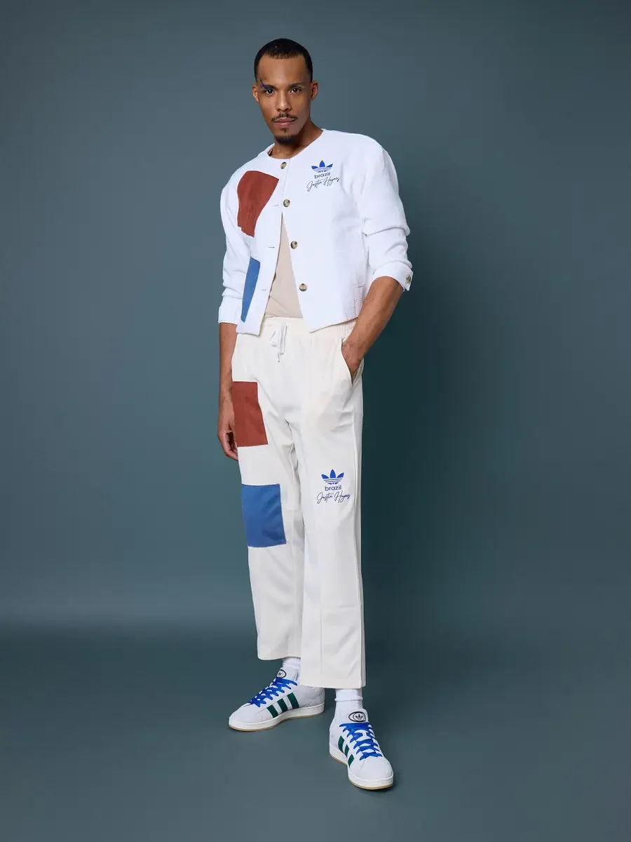 JUS10H x Adidas Brasil campaign, full-length standing shot, white textured patchwork cardigan with terracotta and blue suede panels over cream patchwork drawstring trousers, Adidas Campus 00s in white with dark green stripes and blue laces, steel blu