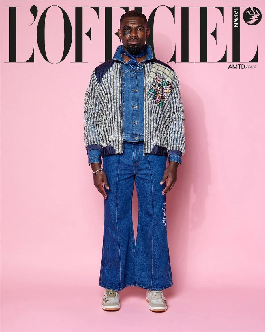 JUS10H Tokyo Remote Collection NYFW 2025 — model Andre in wide-leg dark indigo flare jeans with JUS10H script and seam detailing, layered under a textured grey stripe puffer bomber jacket with multicolor mosaic embroidered patchwork panel, denim butt