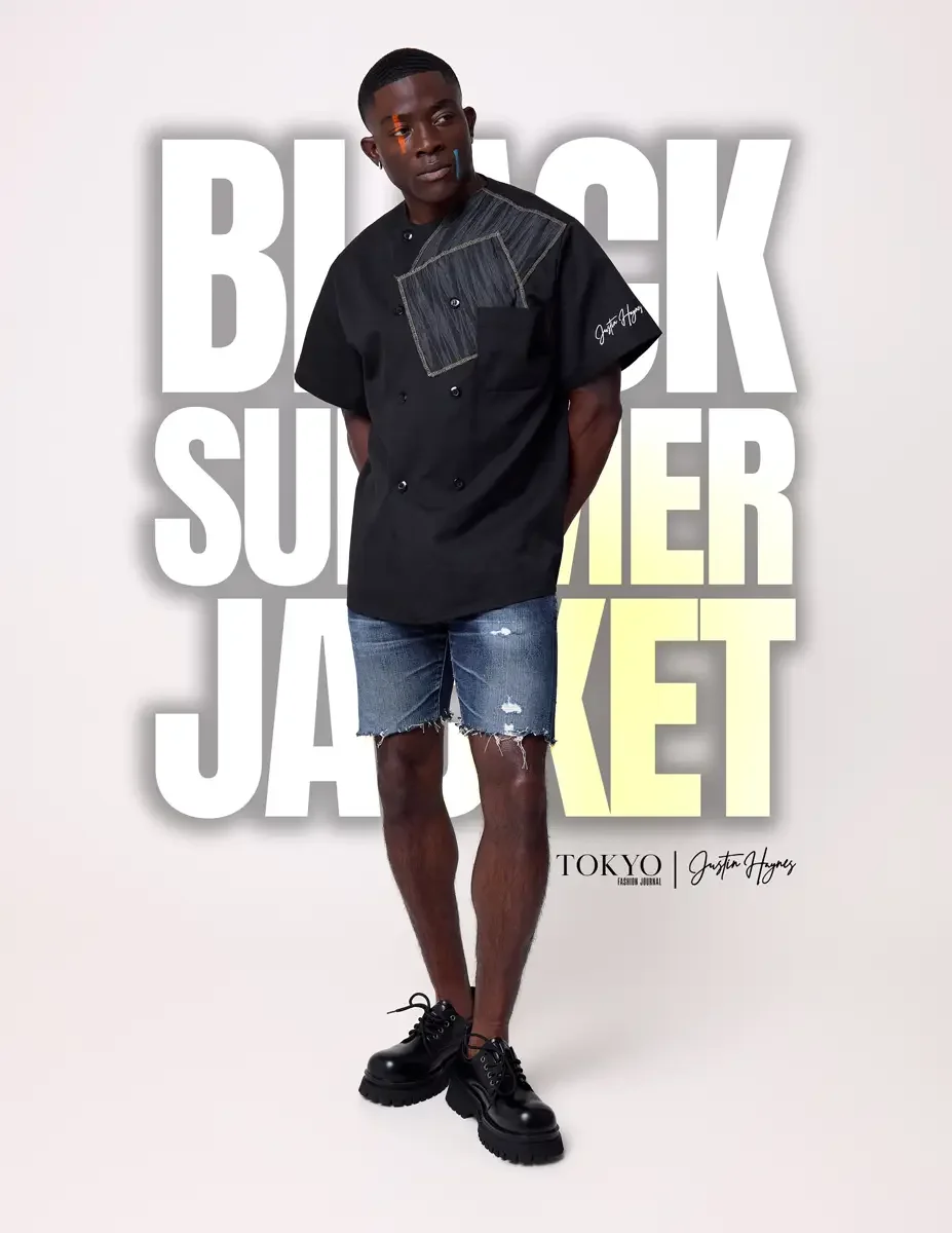 JUS10H Black Summer Jacket lookbook, male model in black double-breasted short-sleeve jacket with gray patchwork chest pocket, distressed denim shorts, black lace-up boots, white background, photographed by Scott Parker Photo