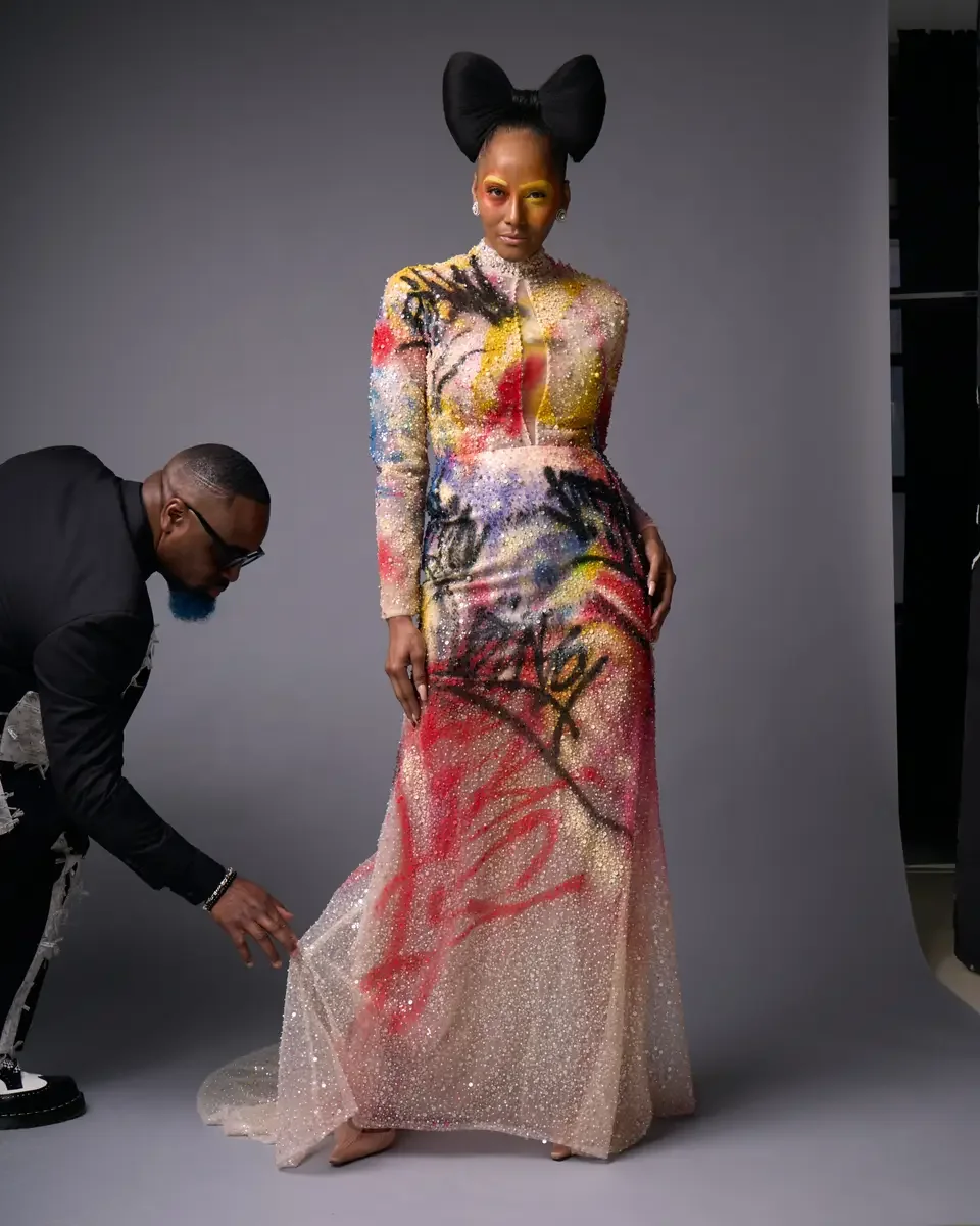 JUS10H Met Monday 2026, designer Justin Haynes adjusting the gown train on set, grey background, photographed by Scott Parker Photo