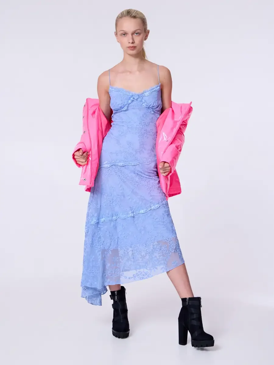 Model portfolio development session, commercial look, hot pink vinyl puffer jacket worn off shoulders over periwinkle blue lace asymmetrical midi dress, full-length, facing camera, jacket held wide at sides, weight shifted, direct gaze, full lace dre