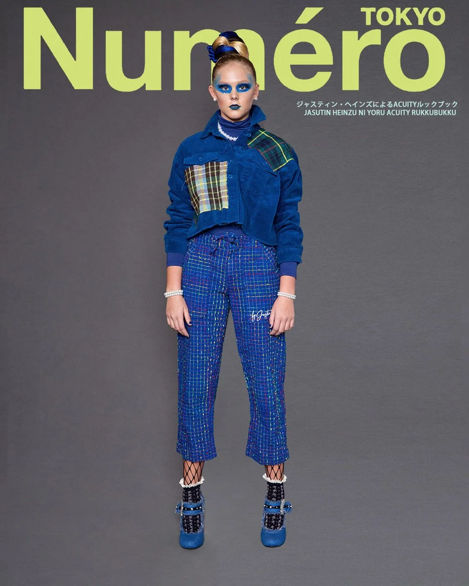 JUS10H by Justin Haynes ACUITY Collection lookbook for Numéro Tokyo by Scott Parker — model in cropped cobalt blue corduroy jacket with tartan and plaid patchwork pockets, paired with multicolor woven check trousers featuring signature embroidery, fi