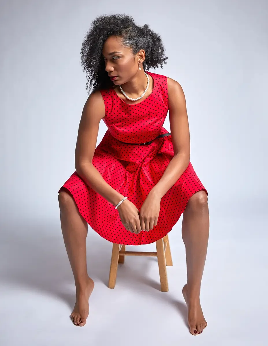 Arielle Chambers, three-quarter portrait, red polka dot dress, pearl necklace detail, East Williamsburg studio test shoot, makeup by Schanica Pickens, photographed by Scott Parker Photo