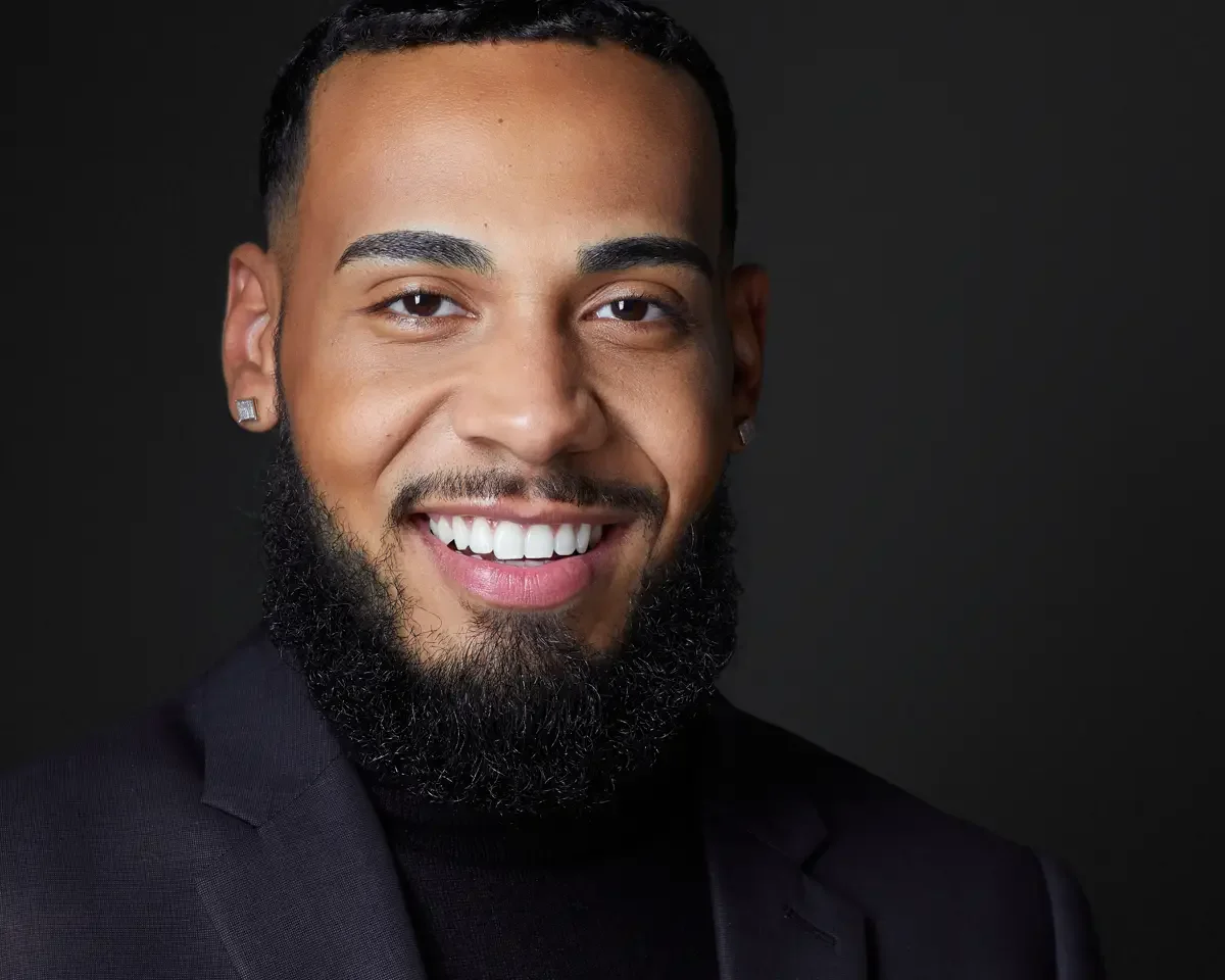 Corporate headshot, dark suit and turtleneck, high energy expression, dark background, Hartford Connecticut, photographed by Scott Parker Photo