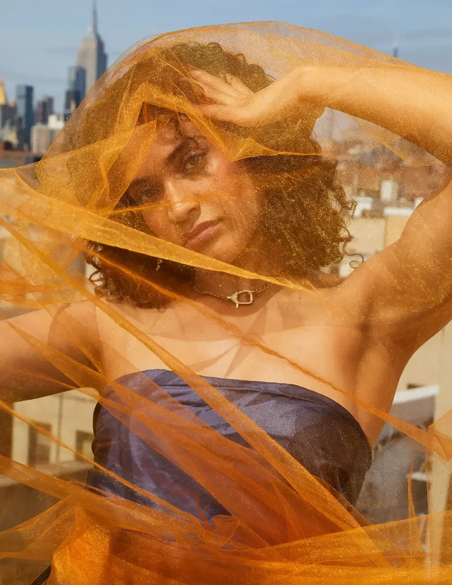 Fashion test shoot, model Ireland T in Amy Page DeBlasio navy strapless top with orange tulle crossing the frame, Manhattan skyline, East Village rooftop, New York City, styling by Matsine Stinson, makeup by Stefani Paige Vivian, photographed by Scot