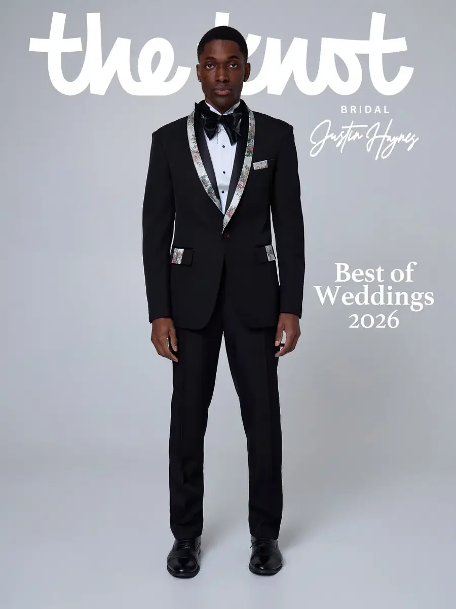 JUS10H 2025 The Knot Bridal feature, Justin Haynes Best of Weddings 2026 cover, black tuxedo with floral-print shawl lapels and matching pocket square, styled with a black satin bow tie and black patent leather oxfords, photographed by Scott Parker P
