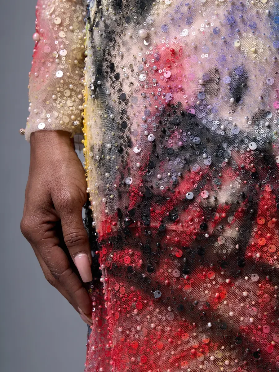 JUS10H Met Monday 2026, gown hip detail, graffiti marks in red and black beneath mixed-scale sequins and seed pearls, grey background, photographed by Scott Parker Photo