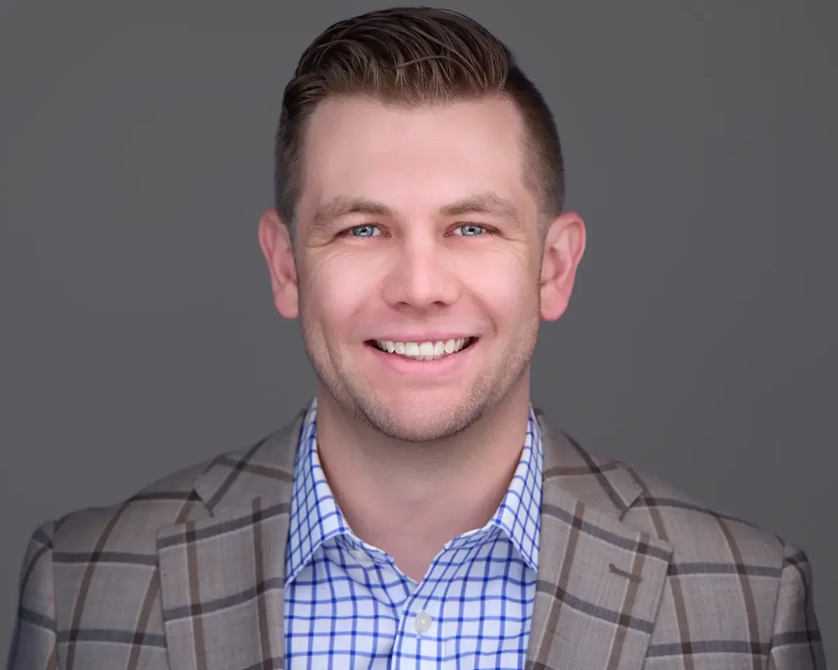 Financial advisor headshot, plaid blazer and checked shirt, confident approachable expression, gray background, Connecticut, photographed by Scott Parker Photo