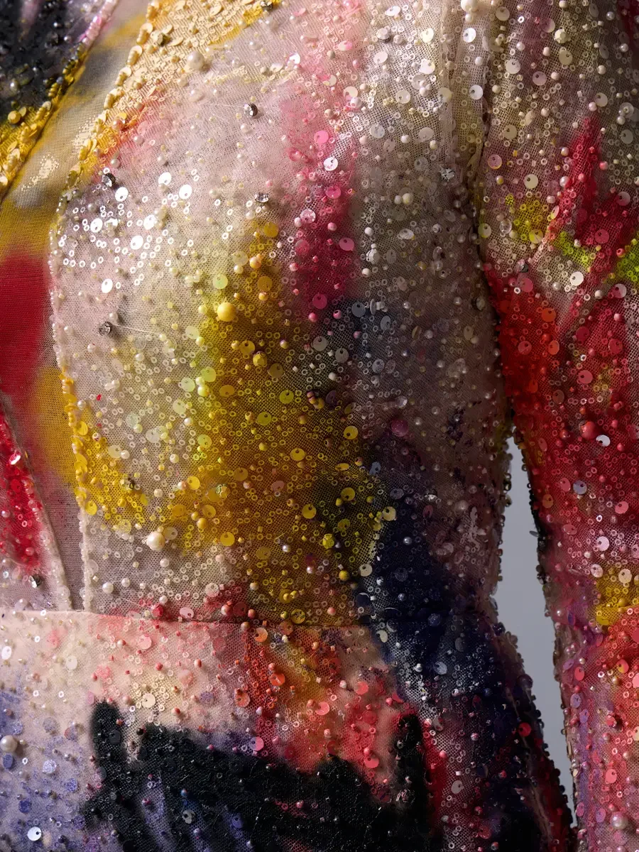 JUS10H Met Monday 2026, gown bodice detail, mixed-scale sequins and seed pearls over hand-painted tulle in yellow, red and pink, grey background, photographed by Scott Parker Photo