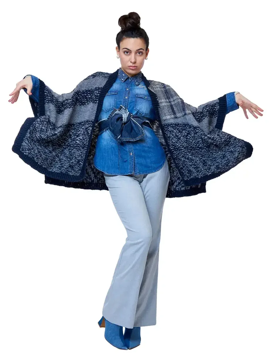 Fashion lookbook photography, denim-on-denim look with oversized navy knit cardigan and flare trousers, white background, photographed by Scott Parker Photo