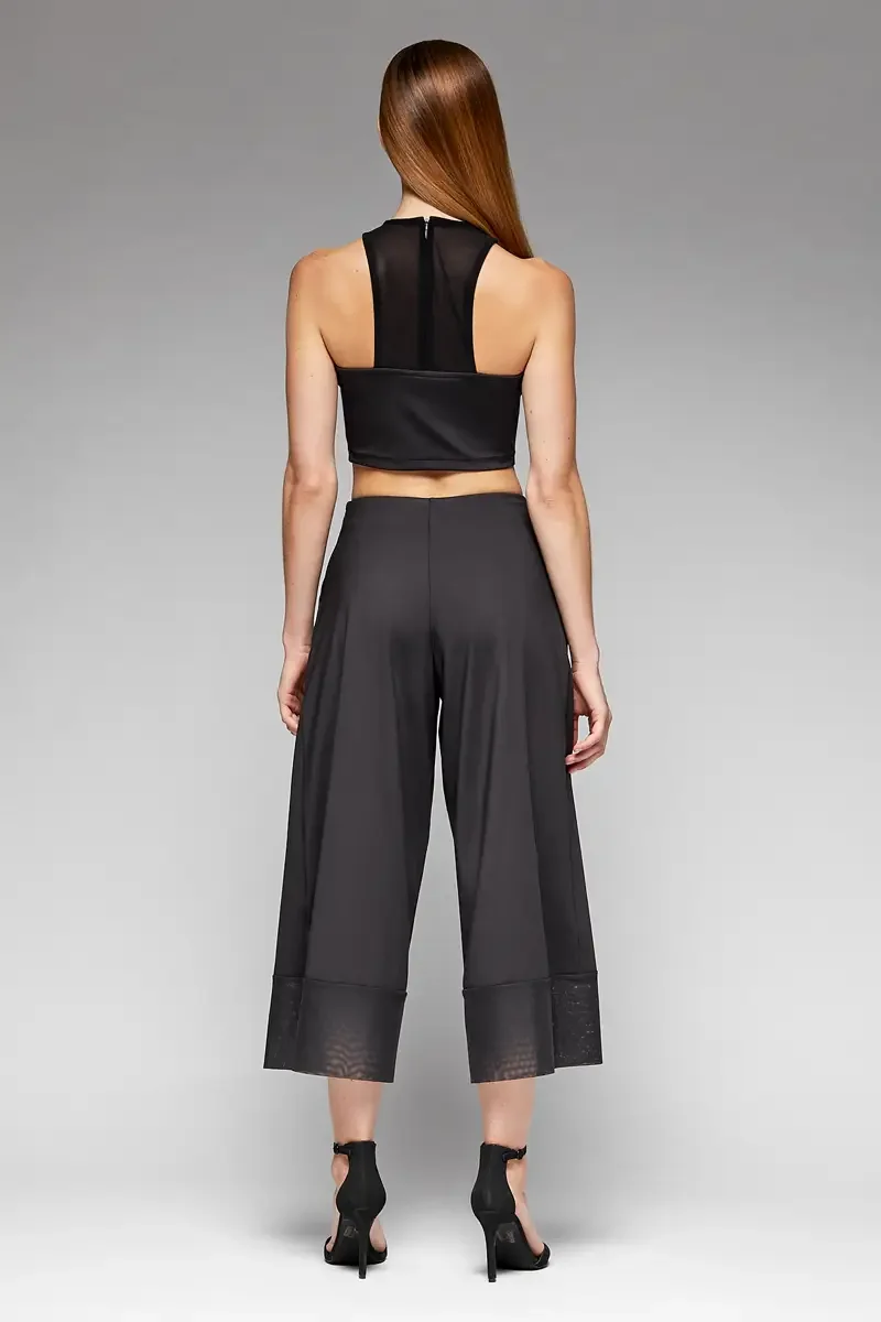 Minika Ko lookbook, black halter crop top and wide-leg culottes set, back view, racerback crop top with sheer mesh back panel and center back zip, culottes with sheer mesh cuff at hem, photographed by Scott Parker Photo