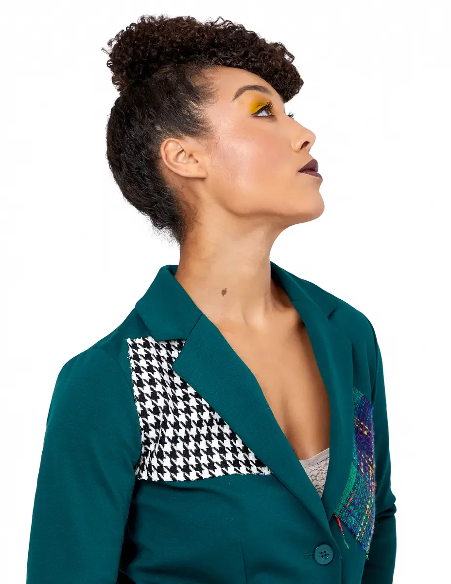 Model portfolio development session, high fashion editorial look, teal single-button blazer with houndstooth appliqué panel at shoulder and multicolor tweed appliqué panel at chest, close-crop, profile gazing upward, gold editorial eye makeup, dark l