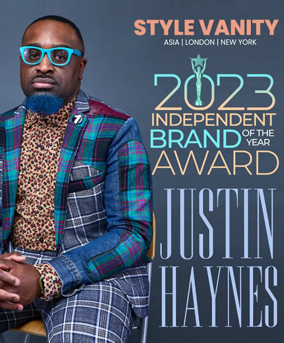 JUS10H 2023 Style Vanity feature, Independent Brand of the Year Award, editorial portrait in patchwork tartan suit with floral shirt, blue frame glasses, photographed by Scott Parker Photo