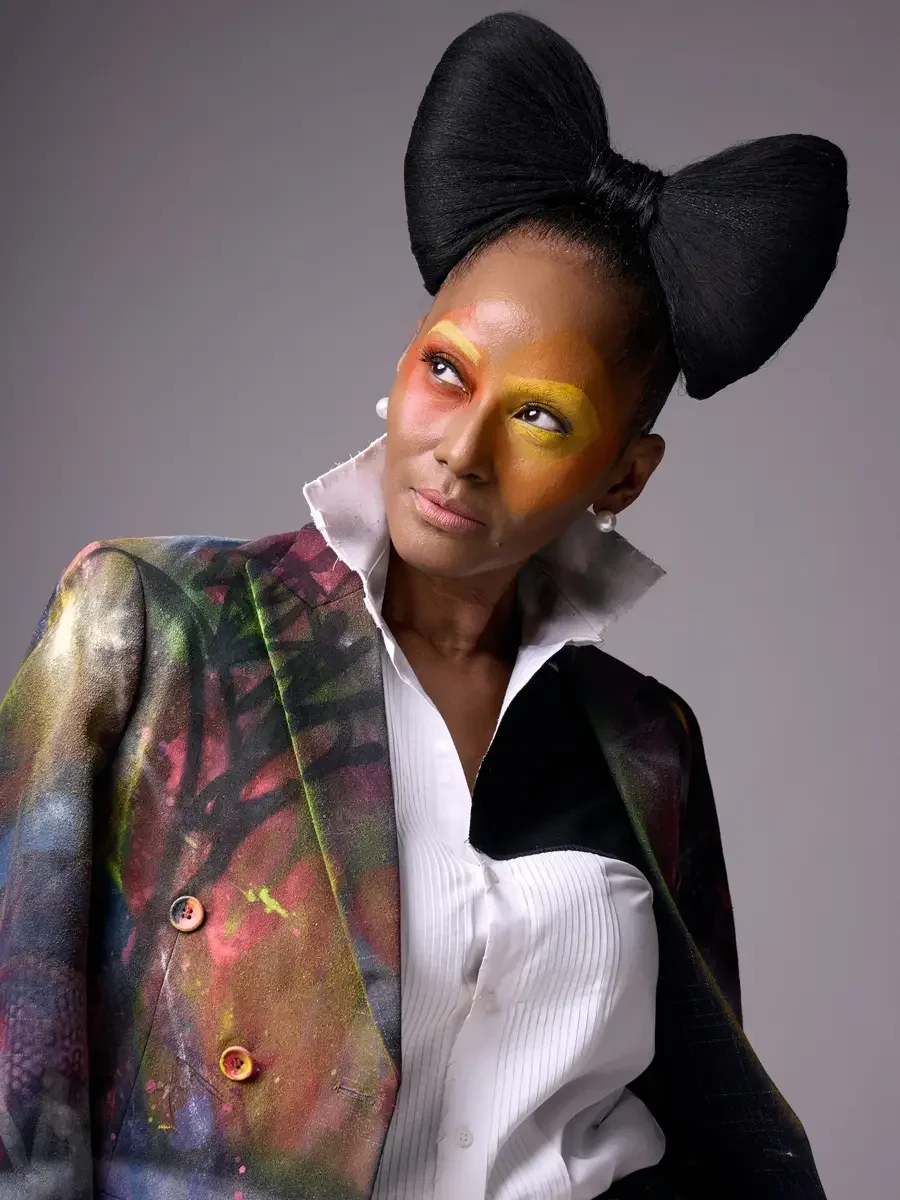JUS10H Met Monday 2026, portrait, hand-painted blazer open with white tuxedo shirt, sculptural black bow, grey background, photographed by Scott Parker Photo