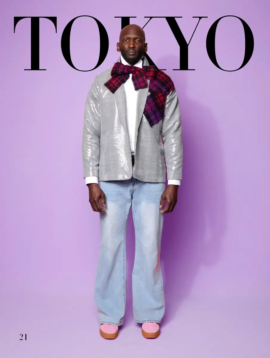 JUS10H 2025 Tokyo lookbook, silver sequin glen plaid blazer with burgundy and purple tartan bow tie over white shirt and light wash wide leg jeans with pink platform shoes, lavender background, photographed by Scott Parker Photo for the Tokyo Fashion