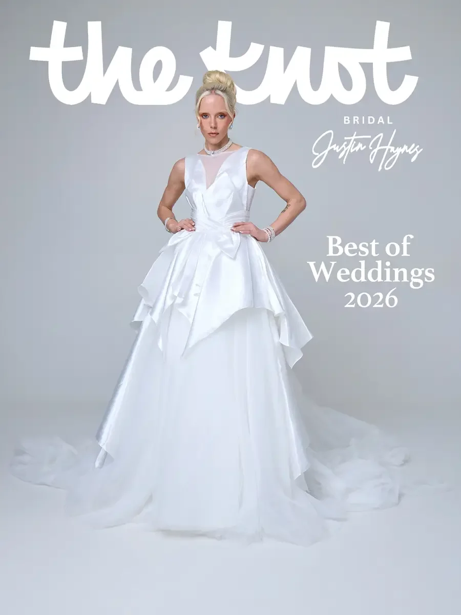 JUS10H 2026 The Knot Bridal feature, Best of Weddings, full-length bridal editorial, structured white ball gown with layered tiered skirt and bow detail, pearl choker, grey background, photographed by Scott Parker Photo