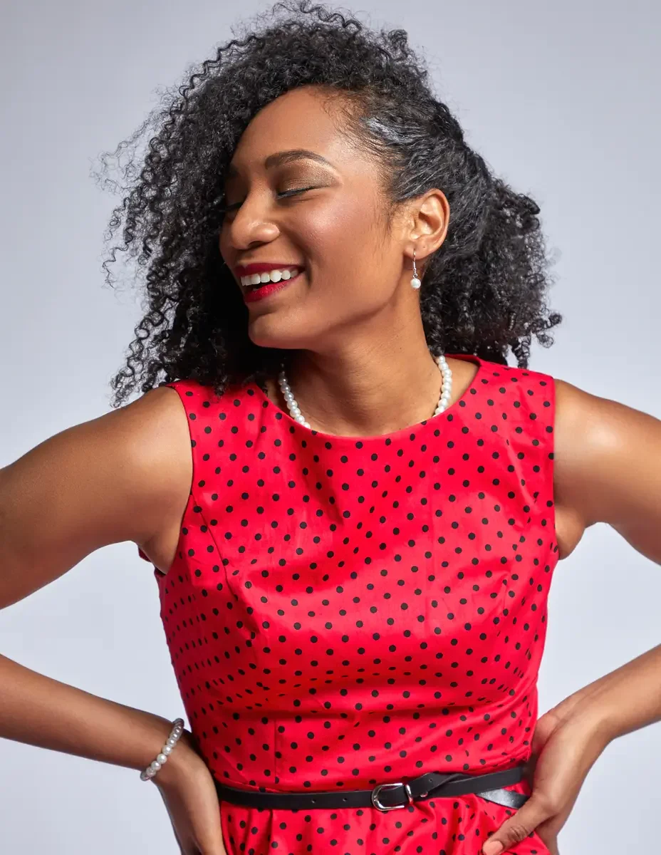 Arielle Chambers, stool lean, upward gaze, red polka dot dress, pearl necklace, East Williamsburg studio test shoot, makeup by Schanica Pickens, photographed by Scott Parker Photo