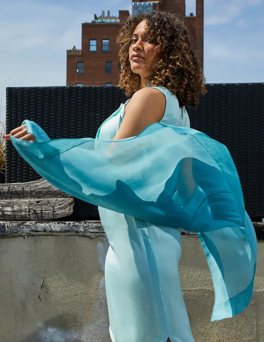 Fashion test shoot, three-quarter, model Ireland T in aqua sleeveless midi dress with turquoise sheer wrap in motion, East Village rooftop, New York City, styling by Matsine Stinson, makeup by Stefani Paige Vivian, photographed by Scott Parker Photo