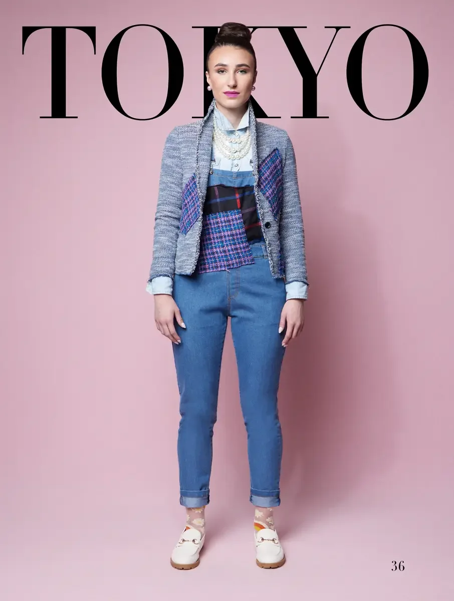 JUS10H 2025 Tokyo lookbook, a model wearing a light blue boucle tweed patchwork blazer with fringe trim over a light blue chambray shirt and a colorful plaid and tweed patchwork vest, light-wash cuffed denim jeans, layered pearl necklaces, sheer dais