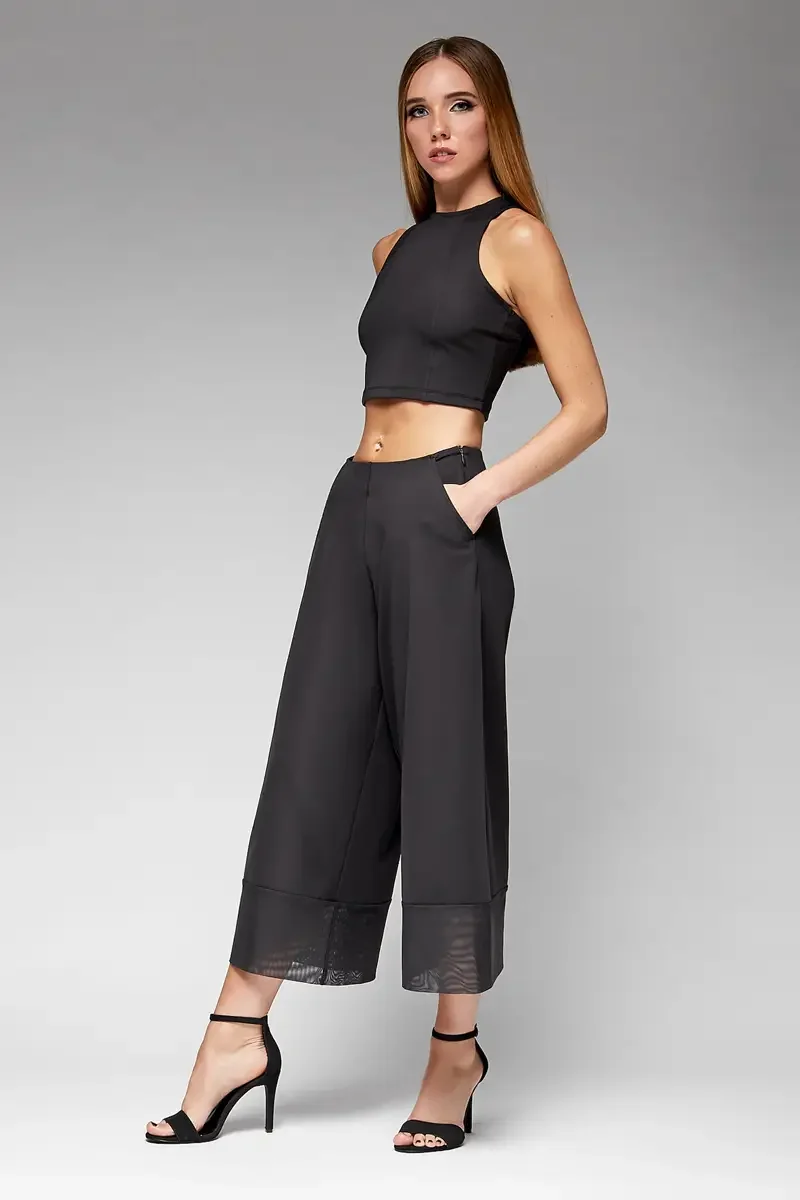 Minika Ko lookbook, black halter crop top and wide-leg culottes set, three-quarter view, high waist, side pockets, sheer mesh cuff at hem, smooth synthetic fabric, photographed by Scott Parker Photo