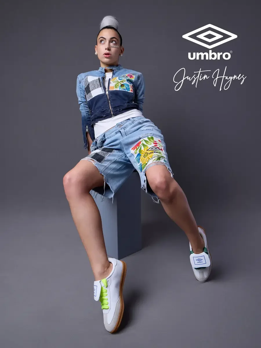 Fashion photographer in Massachusetts for the Umbro France collection. Vanessa seated and leaning back with one leg extended in a cropped two-tone denim moto jacket with floral patchwork panels and matching distressed denim bermuda shorts, styled by 