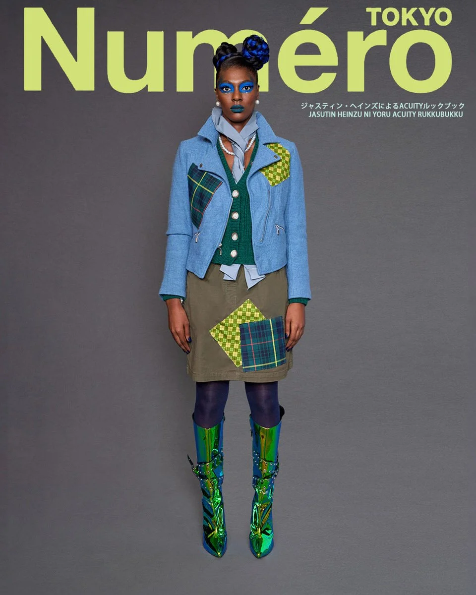 JUS10H by Justin Haynes ACUITY Collection lookbook for Numéro Tokyo by Scott Parker — model in cropped chambray moto jacket with green checkered and tartan patchwork pockets, layered over emerald green cardigan and pale blue blouse, paired with olive