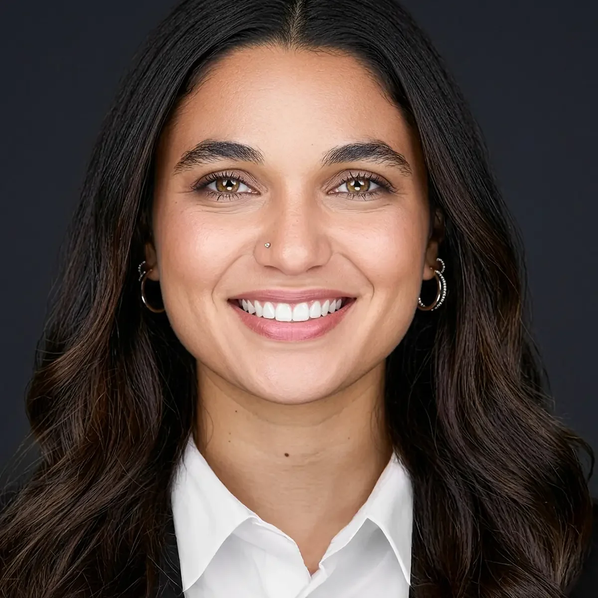 close cropped professional business headshot of a woman with an approachable smile, business attire white collared shirt blue jacket