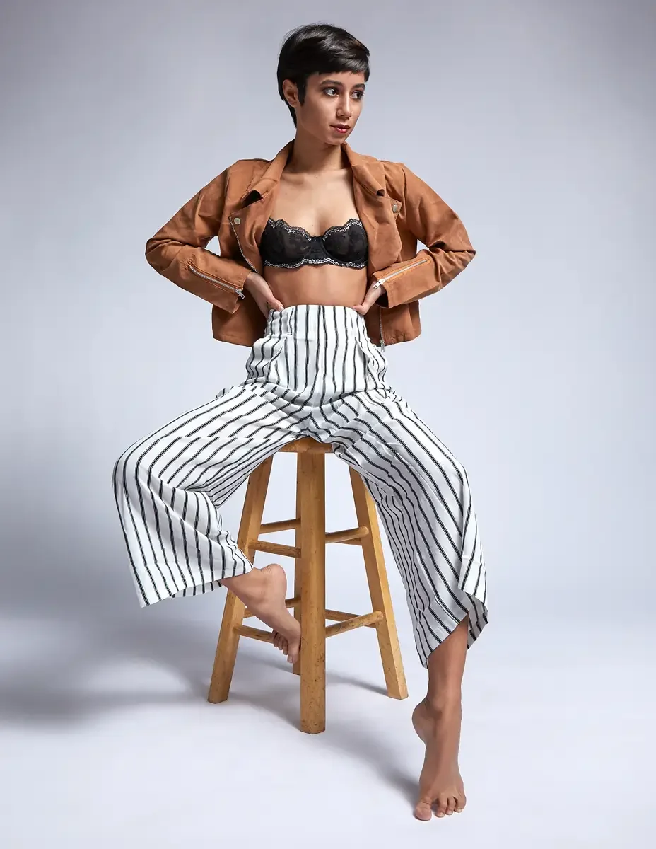Eloissa, seated, black lace bralette and striped high-waisted wide-leg trousers, floral forearm tattoo, studio stool, East Williamsburg studio test shoot, makeup by Schanica Pickens, photographed by Scott Parker Photo